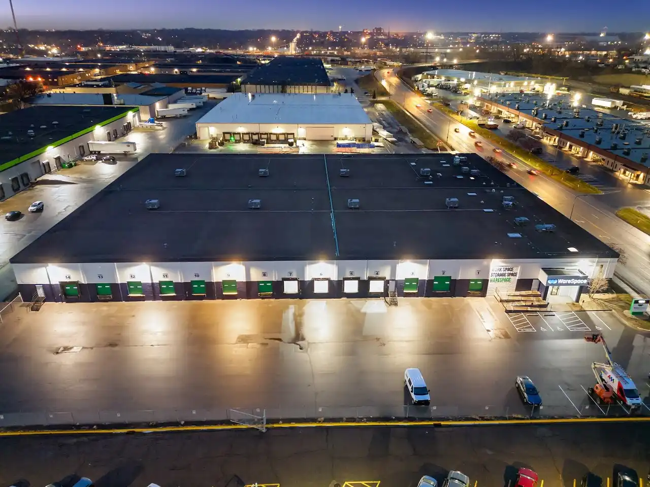 Aerial dusk view of a WareSpace facility with loading docks and lit parking lot